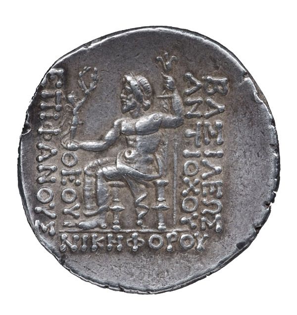 Tte laure de Zeus sous les traits d'Antiochos IV. / Zeus assis tenant un sceptre et une Victoire aile ; lgende grecque #BASILEWS ANTIOCOU QEOU EPIFANOUS NIKEFOROU.#